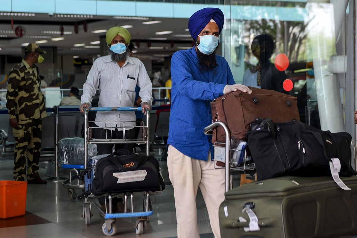 ndian nationals after returning from Sharjah in the United Arab Emirates (UAE) with a special flight arrive before boarding a bus taking them to a quarantine facility, amid concerns over the spread of the COVID-19 coronavirus, at Sri Guru Ram Dass Jee International Airport on the outskirts of Amritsar. Credits: AFP Photo