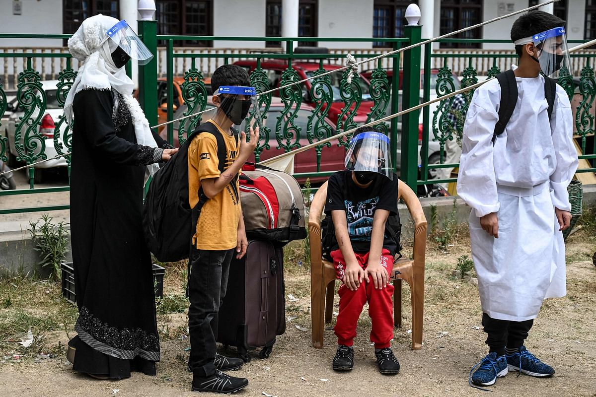 People wearing face shields wait at a COVID-19 coronavirus testing centre after their arrival in Srinagar. Credits: AFP Photo