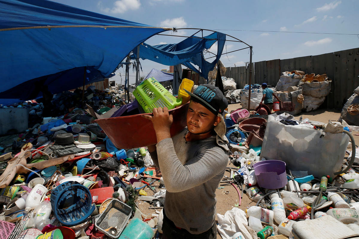 A Palestinian worker carries plastic items collected to be recycled in a factory in the northern Gaza Strip July 13, 2020. Picture taken July 13, 2020. Credit: REUTERS