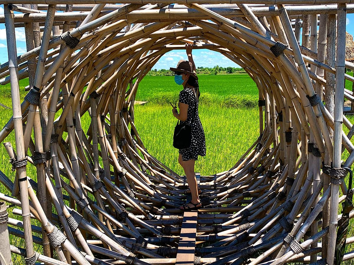 A tourist walks in a bamboo installation for a Thai restaurant beside a rice field Ayutthaya on July 17, 2020. Credit: AFP