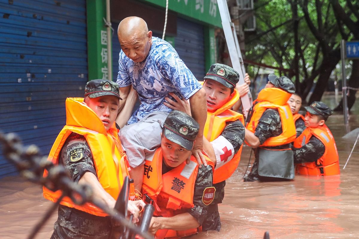 China's paramilitary police officers evacuating residents at a flooded area due to heavy rains in China's southwestern Chongqing. Credit: AFP