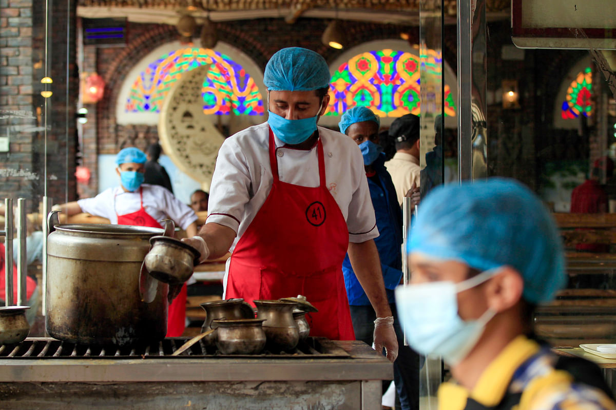 A restaurant worker, wearing a protective face mask, waits for clients at a restaurant in the Yemeni capital Sanaa on July 16, 2020, following the easing of measures against the COVID-19 novel coronavirus pandemic. Credit: AFP