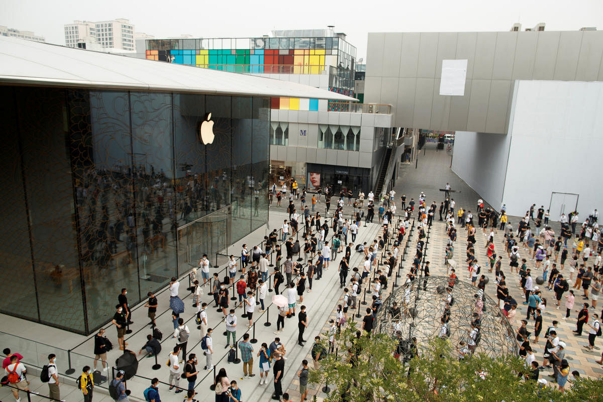 People observe social distancing as they wait for the opening of the new Apple flagship store following an outbreak of the coronavirus disease (COVID-19) in Sanlitun in Beijing, China, July 17, 2020. Credit: REUTERS