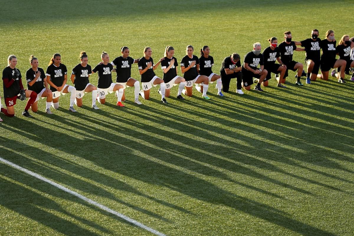 The OL Reign FC and the Chicago Red Stars kneel during the national anthem prior to the quarterfinal match of the NWSL Challenge Cup at Zions Bank Stadium on July 18, 2020 in Herriman, Utah. Credit: Getty Images/AFP