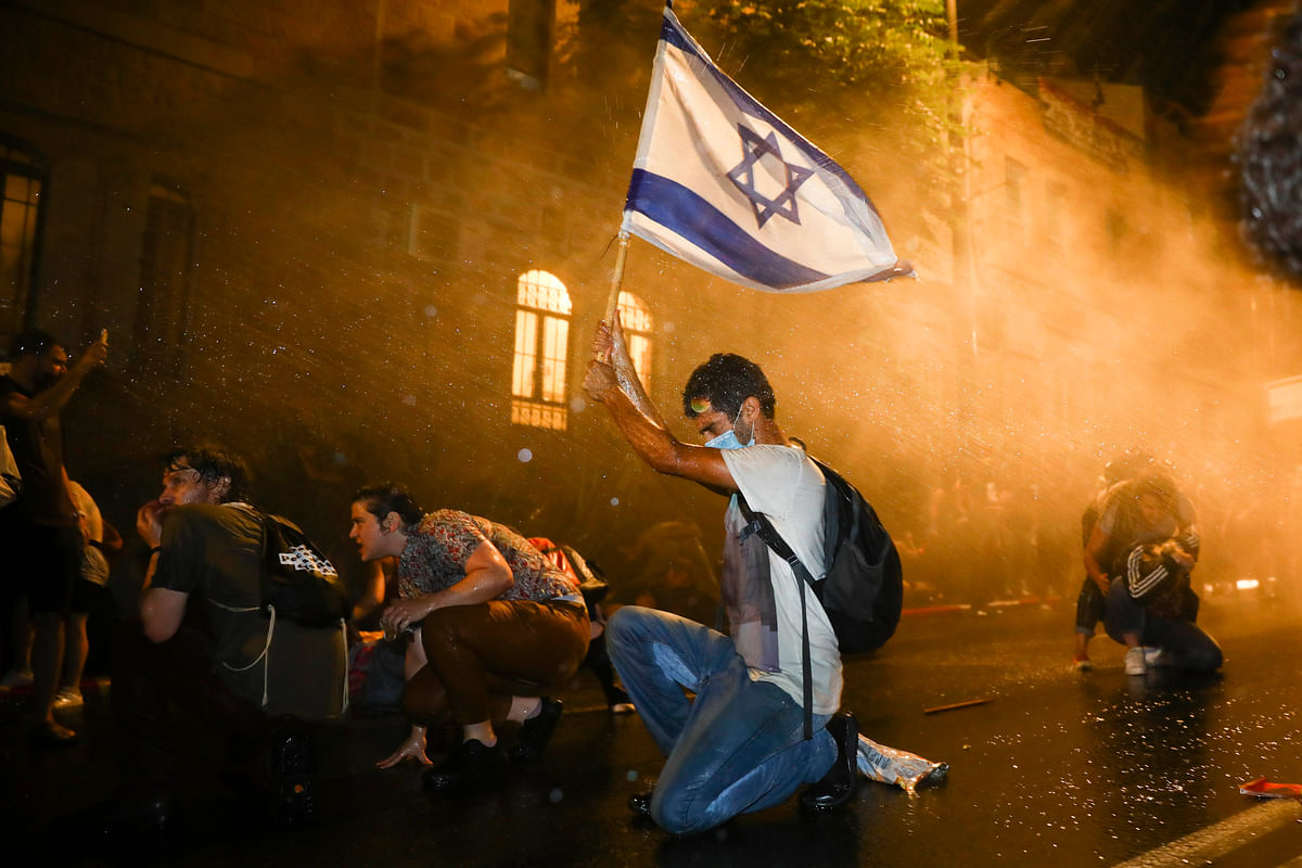Israeli police use a water cannon to disperse people during a protest against Israeli Prime Minister Benjamin Netanyahu in Jerusalem, Saturday, July 18, 2020. Protesters demanded that the embattled leader resign as he faces a trial on corruption charges and grapples with a deepening coronavirus crisis. Credit: AP/PTI Photo