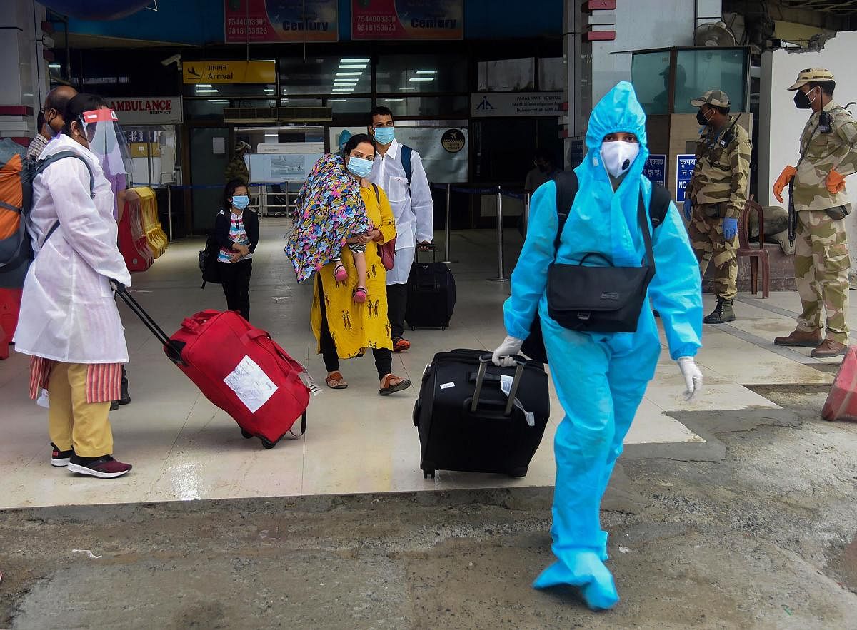 Passengers wearing face masks arrive at Jai Prakash Narayan Airport during total lockdown in Patna. Credit: PTI