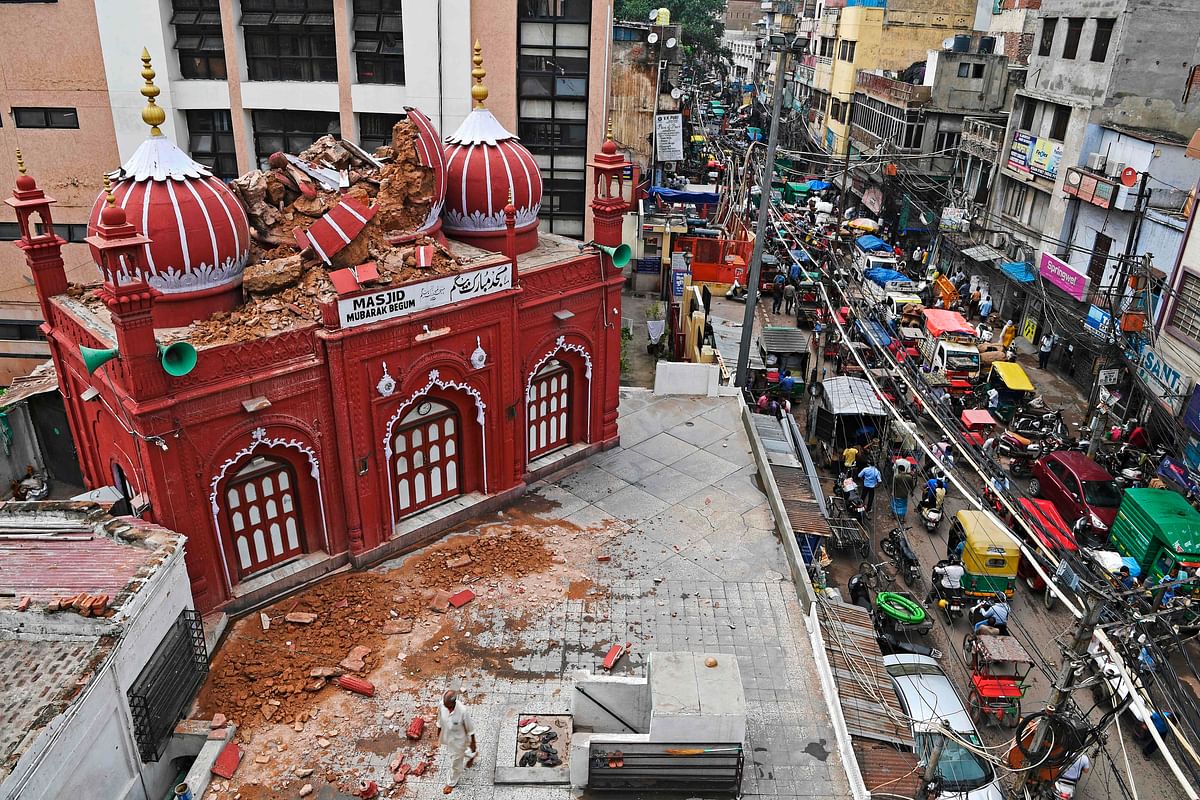 A partially damaged portion of historic Mubarak Begum masjid (mosque) is seen next to a busy road after heavy rains in the old quarters of New Delhi on July 20, 2020. - Torrential rains during the monsoon season between June and September trigger floods, landslides and lightning strikes across the region, with hundreds dying every year. Credit: AFP