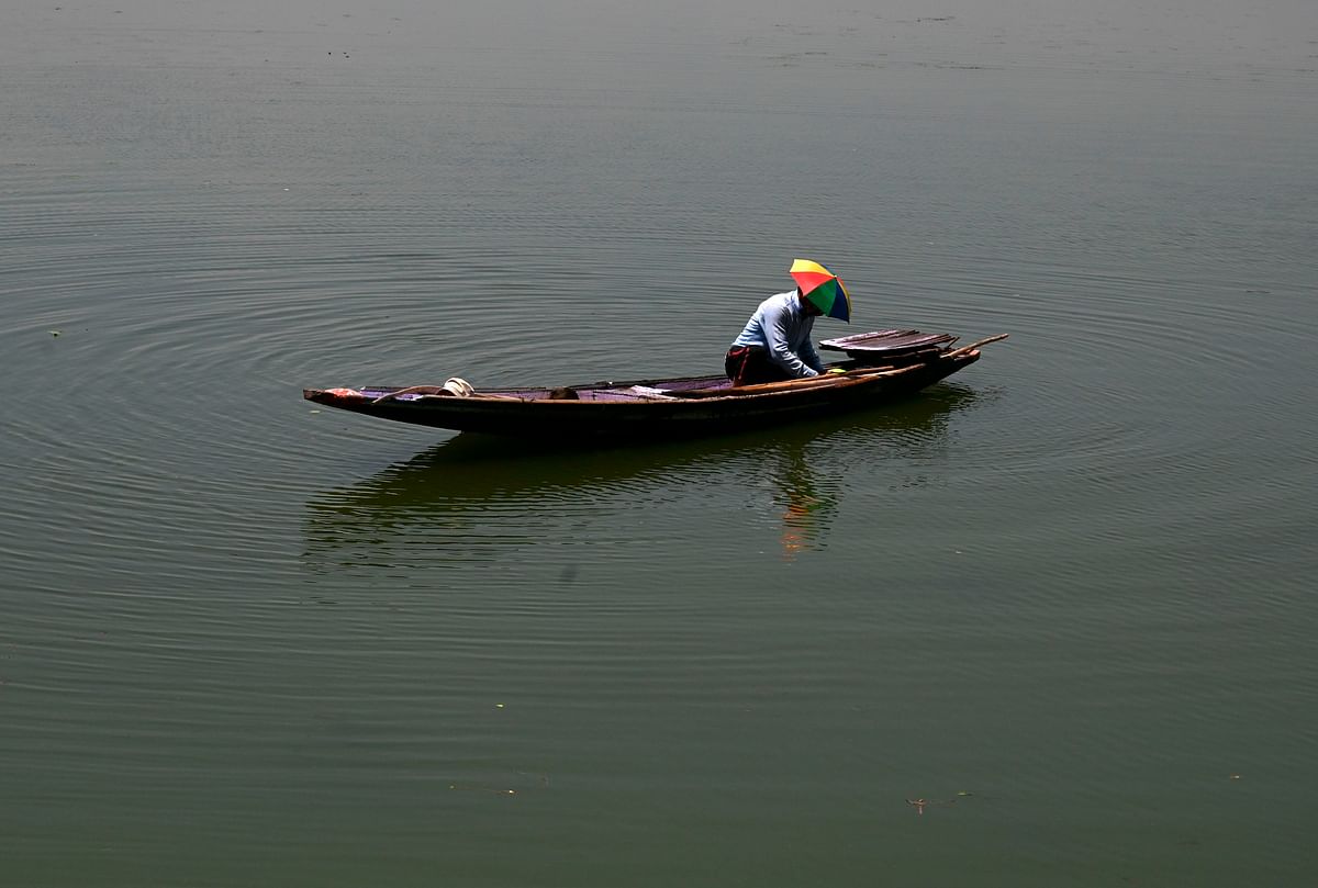 A man works inside a boat at Dal Lake in Srinagar on July 20, 2020. Credit: AFP