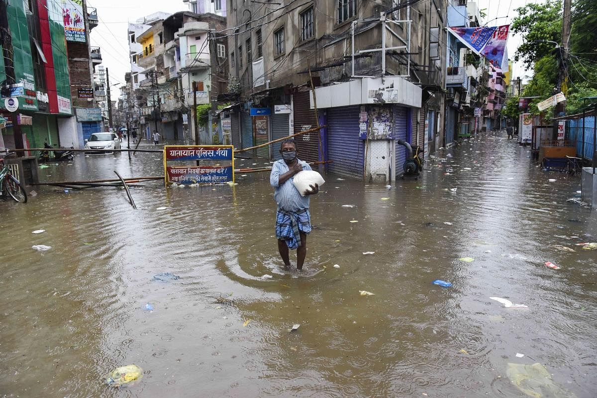A man walks on a waterlogged street after heavy rainfall in Patna, Monday, July 20, 2020. Credit: PTI Photo
