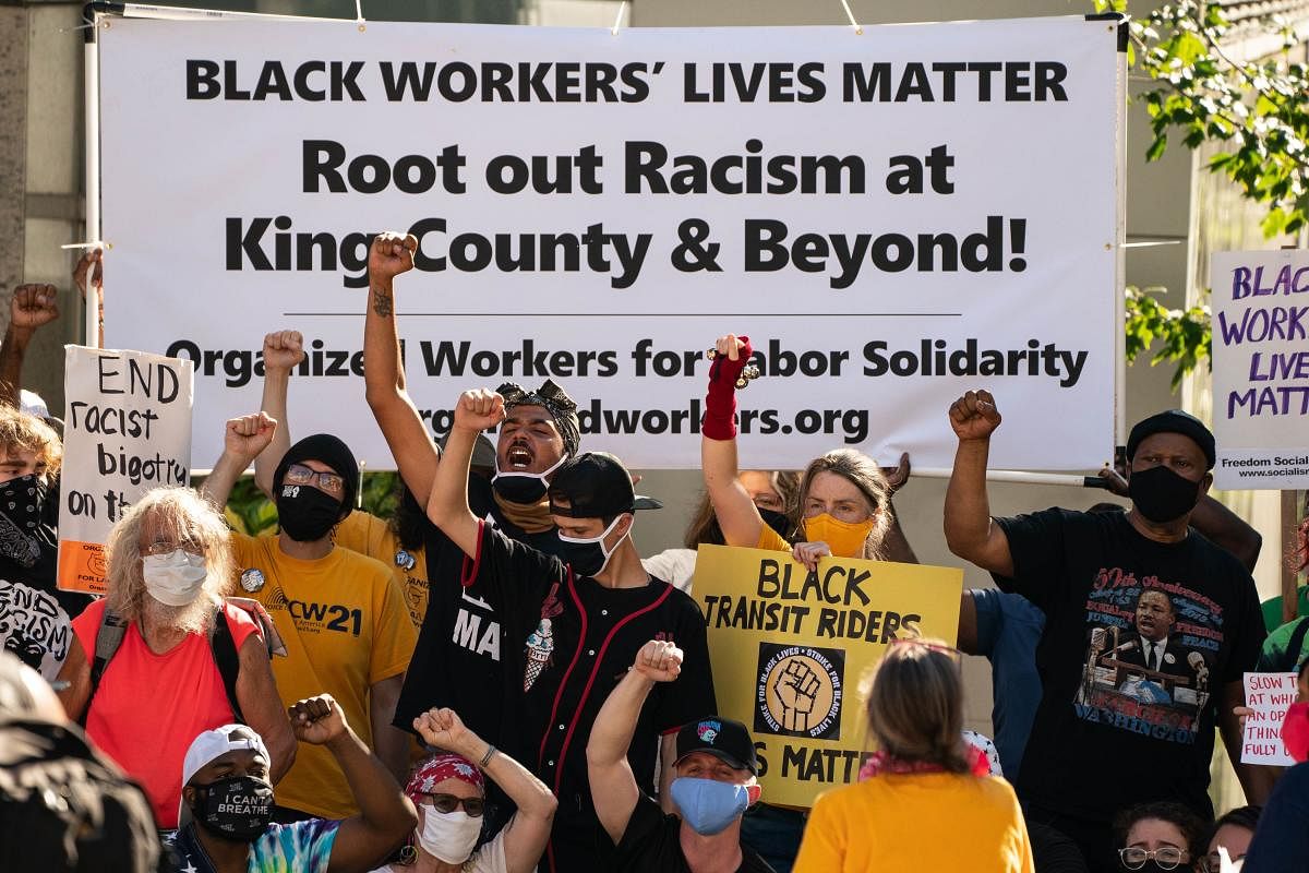 Demonstrators pose for group photos during a picket and rally event outside the office of King County Executive Dow Constantine as part of the nationwide Strike For Black Lives on July 20, 2020 in Seattle, Washington. Organized by racial justice groups in partnership with labor unions, the nationwide events included at least two rallies in the Seattle area. Credit: AFP Photo