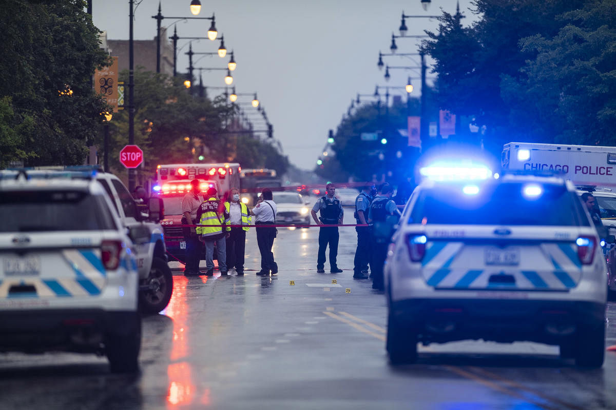 Chicago police investigate the scene of a mass shooting where more then a dozen people were shot in the Gresham neighborhood, of Chicago, Credit: AP