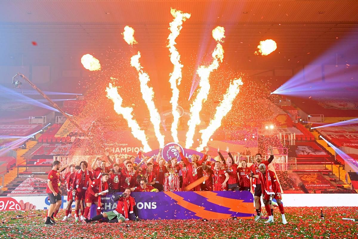 A fire display lights up the stadium as Liverpool players pose during the Premier League trophy presentation following the English Premier League football match. Credit: AFP