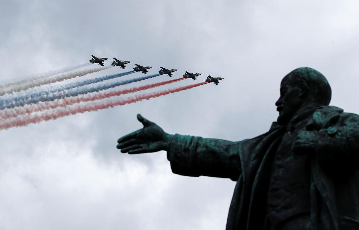 Russian Su-25 jet aircraft release smoke in the colours of the Russian state flag as they fly above a monument to Soviet state founder Vladimir Lenin during a rehearsal for the Navy Day parade in Saint Petersburg. Credit: Reuters