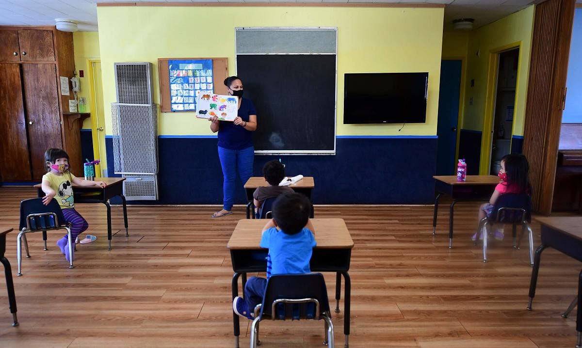 Children in a pre-school class, wearing masks and at desks spaced apart as per coronavirus guidelines during summer school sessions in Monterey Park, California. Photo: AFP