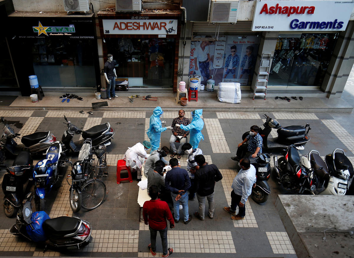 Healthcare workers wearing personal protective equipment (PPE) take swab from a man for a rapid antigen test in a market area, amidst the coronavirus disease outbreak, in Ahmedabad, India, July 27, 2020. Credit: Reuters Photo