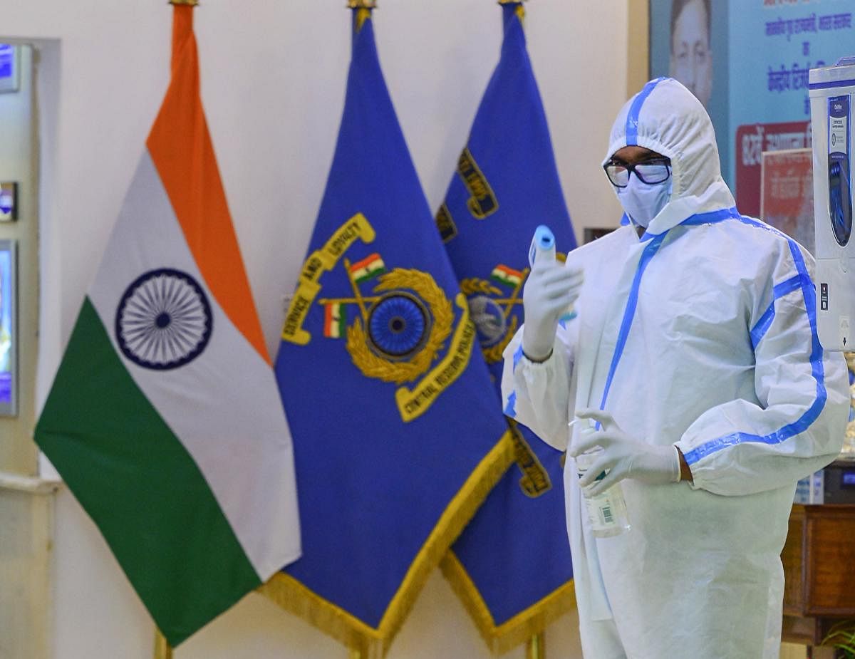 A CRPF person wearing a PPE waits to conducts thermal screening of officials arriving to attend a function on the occasion of 82nd Raising Day of CRPF, in New Delhi, Monday, July 27, 2020.. Credit: PTI Photo