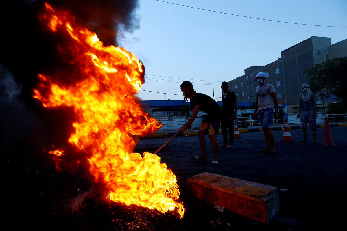 Iraqi demonstrators burn tires to block the road during a protest over poor public services in the holy city of Najaf. Credit: Reuters Photo