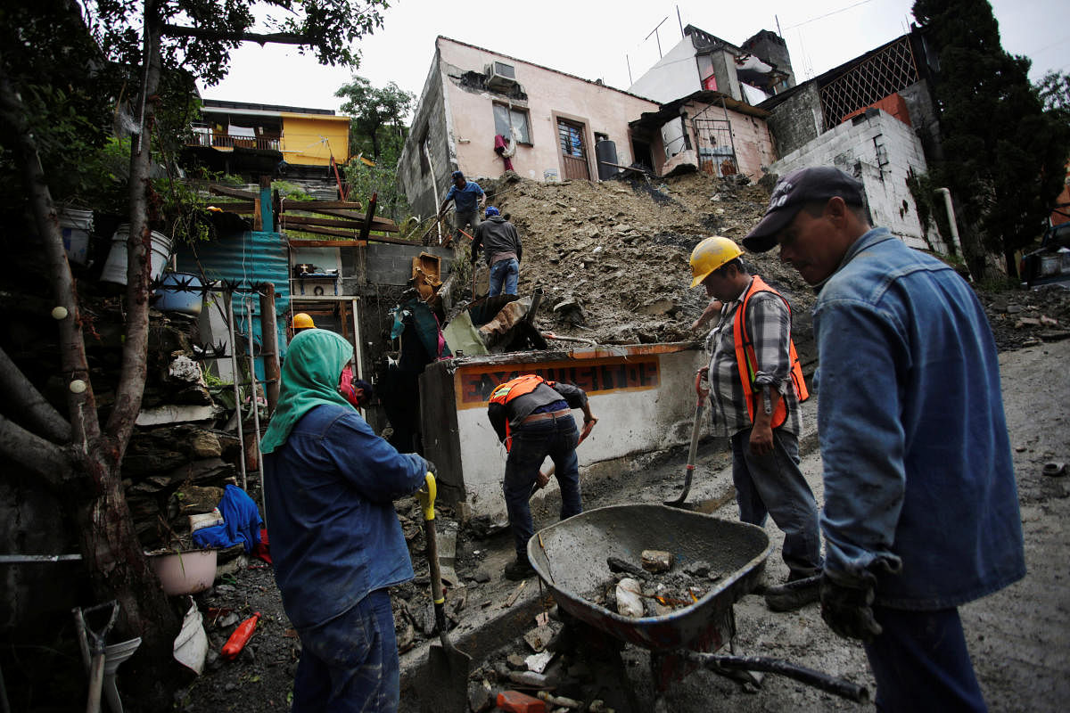 People work to remove mud and rocks after a landslide in the aftermath of Storm Hanna in Monterrey. Credit: Reuters Photo