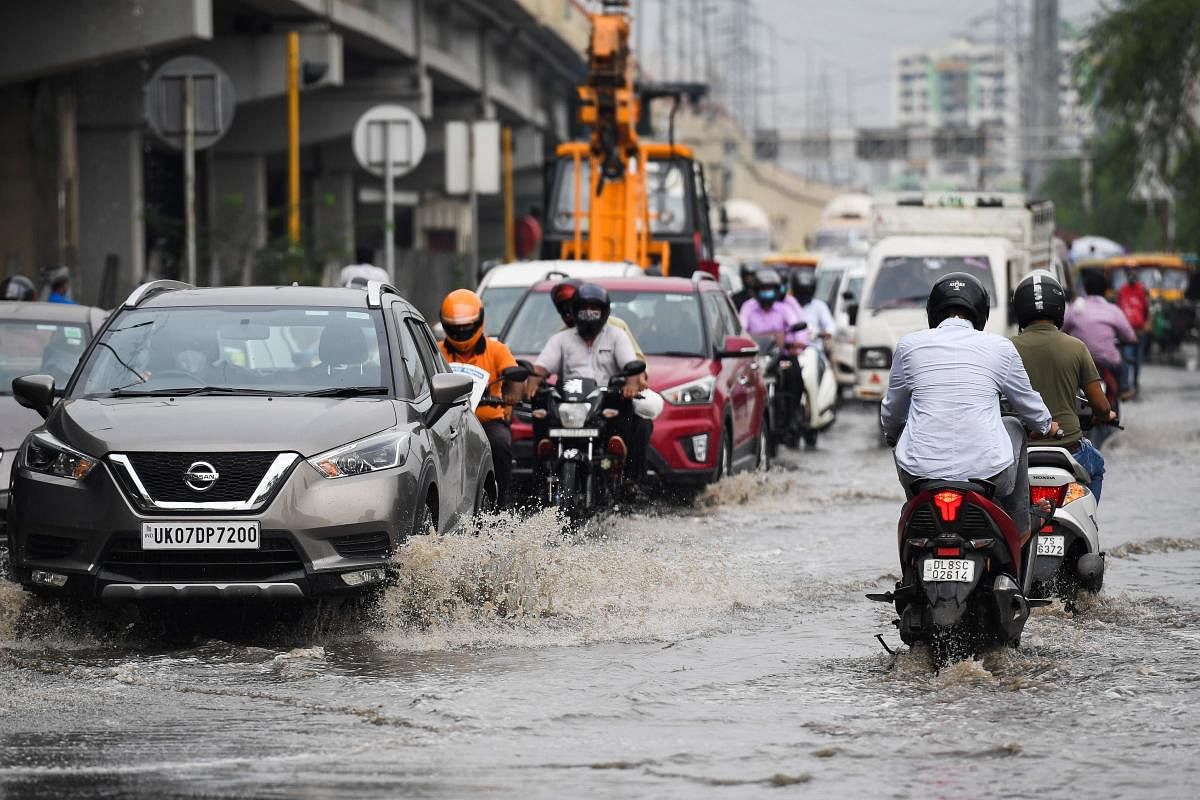 Commuters make their way along a waterlogged road after a monsoon rain in New Delhi. Credit: AFP