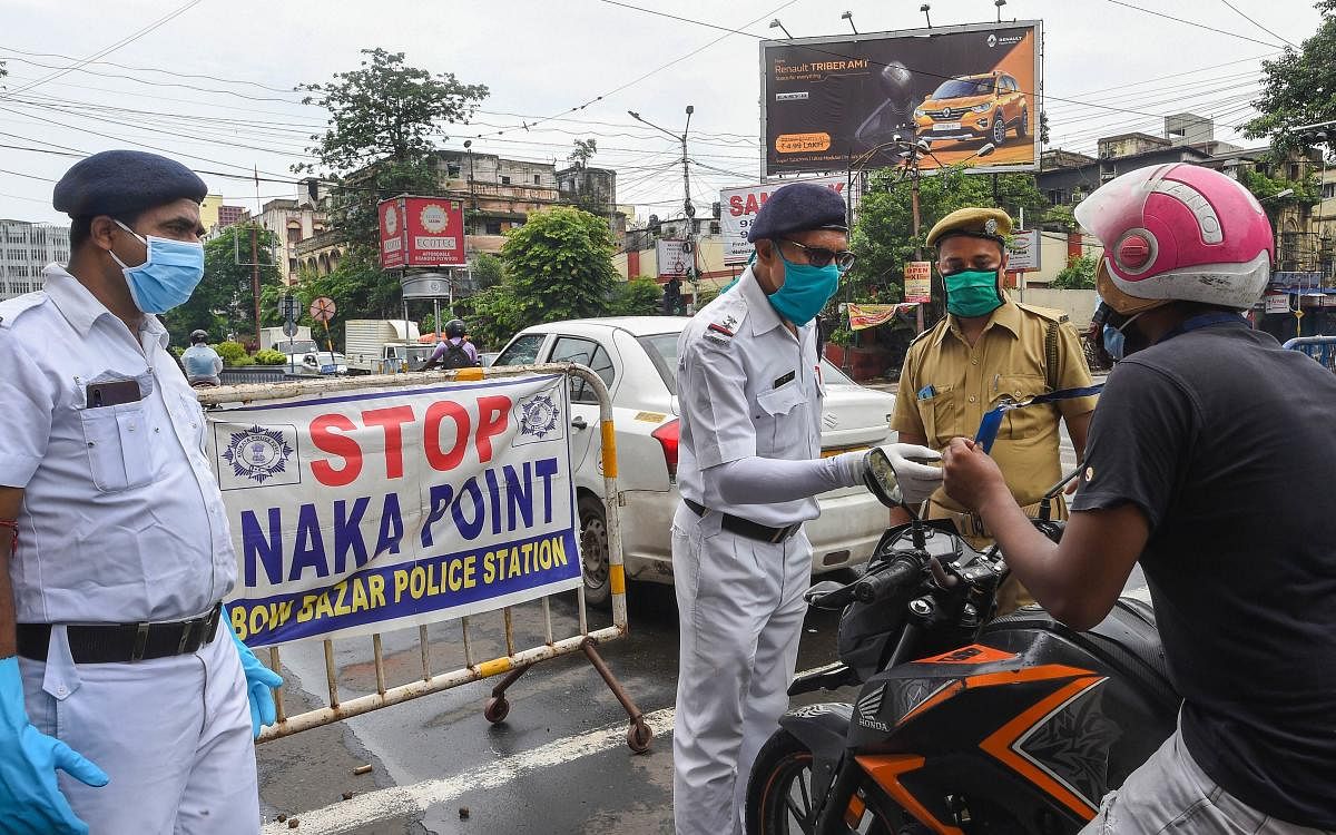 Police personnel urge a commuter to remain indoors during the biweekly complete lockdown to curb the spread of coronavirus disease. Credit: PTI
