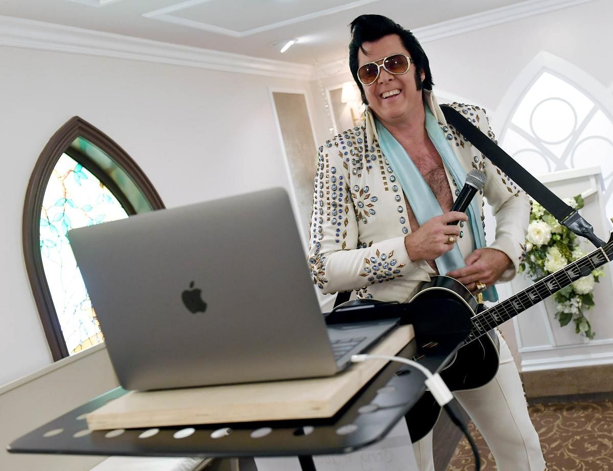 Elvis Presley impersonator and chapel co-owner Brendan Paul performs a live wedding vow renewal ceremony using the Zoom videoconferencing. Credit: AFP