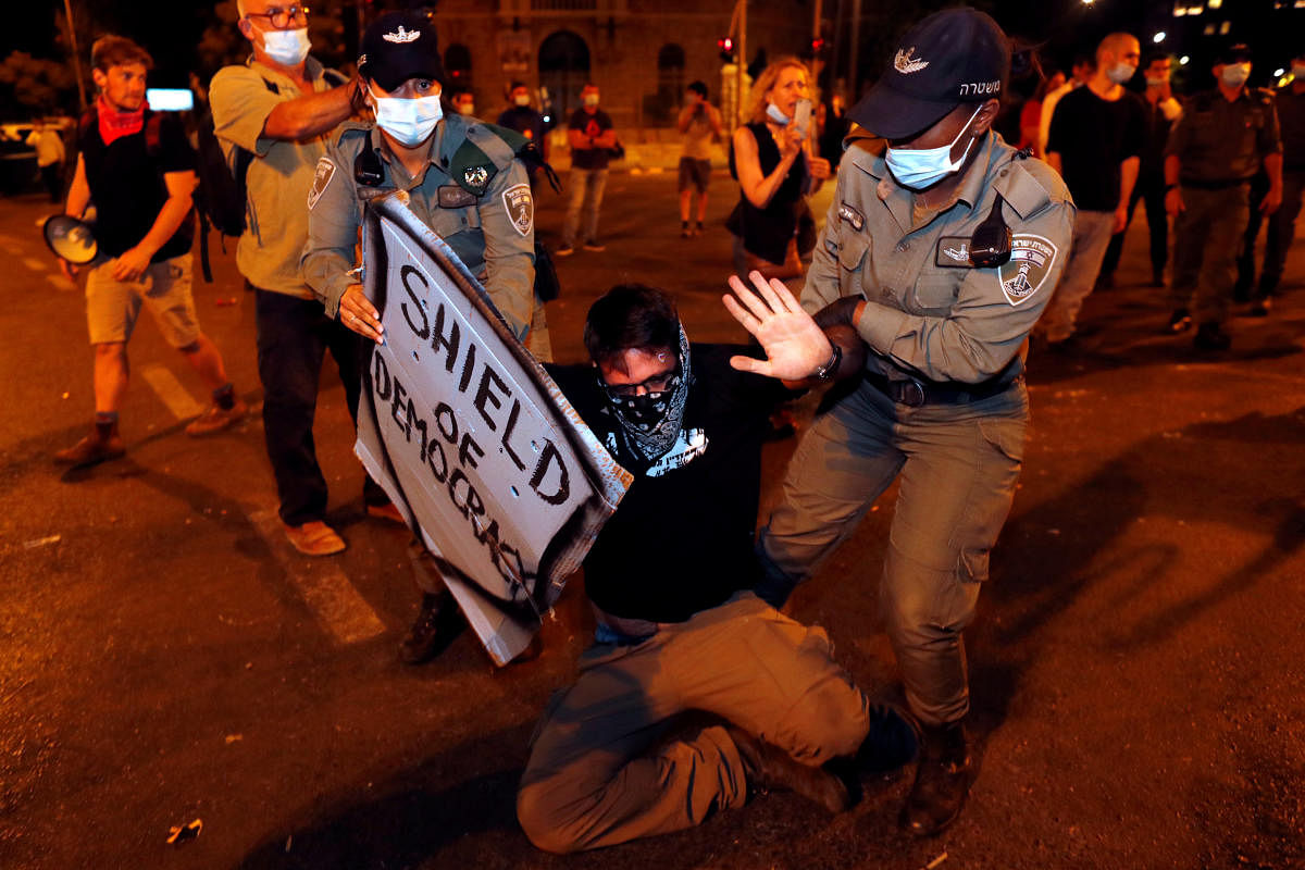 Police take a protester off the street during a demonstration against Israeli Prime Minister Benjamin Netanyahu's alleged corruption . Credit: Reuters