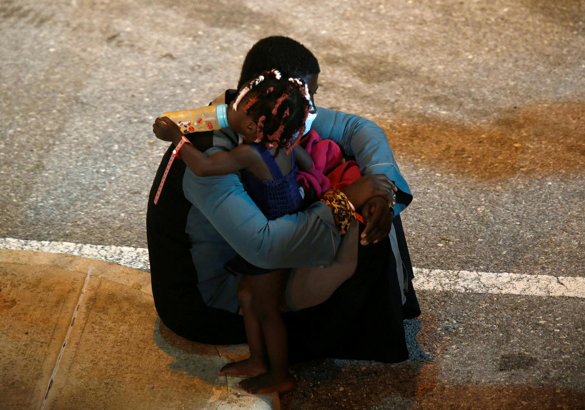 A rescued migrant embraces a child after disembarking an Armed Forces of Malta vessel in Senglea, in Valletta's Grand Harbour, as the coronavirus disease (COVID-19) outbreak continues in Malta August 3, 2020. Credit: REUTERS Photo