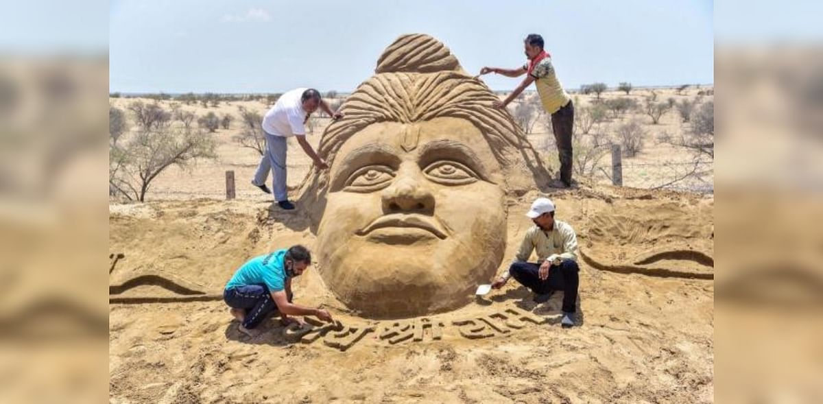 Artists give final touch to a sand sculpture of Lord Ram in Bikaner. Credit: PTI Photo