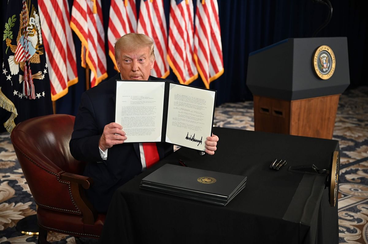 US President Donald Trump signs executive orders extending coronavirus economic relief, during a news conference in Bedminster, New Jersey, on August 8, 2020. Credit: AFP
