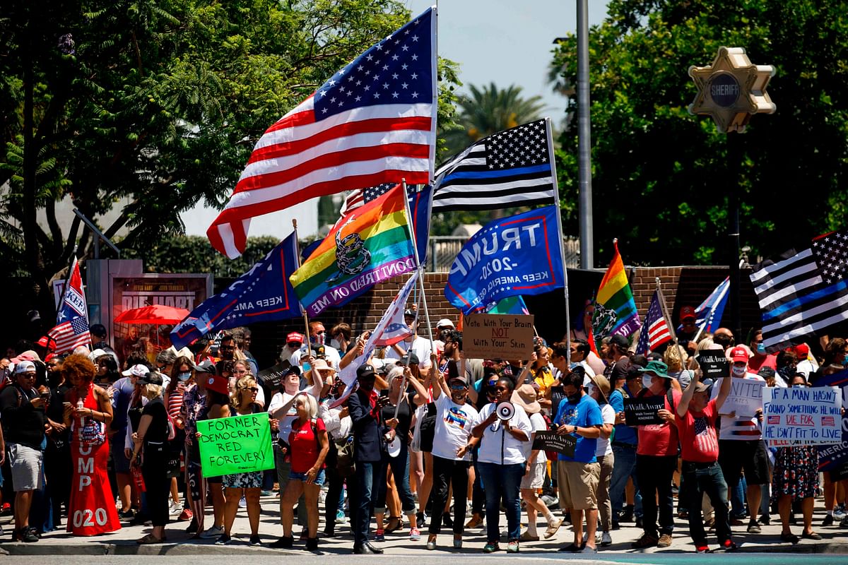 Demonstrators wave flags as they march in support of the US president during a WalkAway rally on August 8, 2020 in West Hollywood, California. Credit: AFP