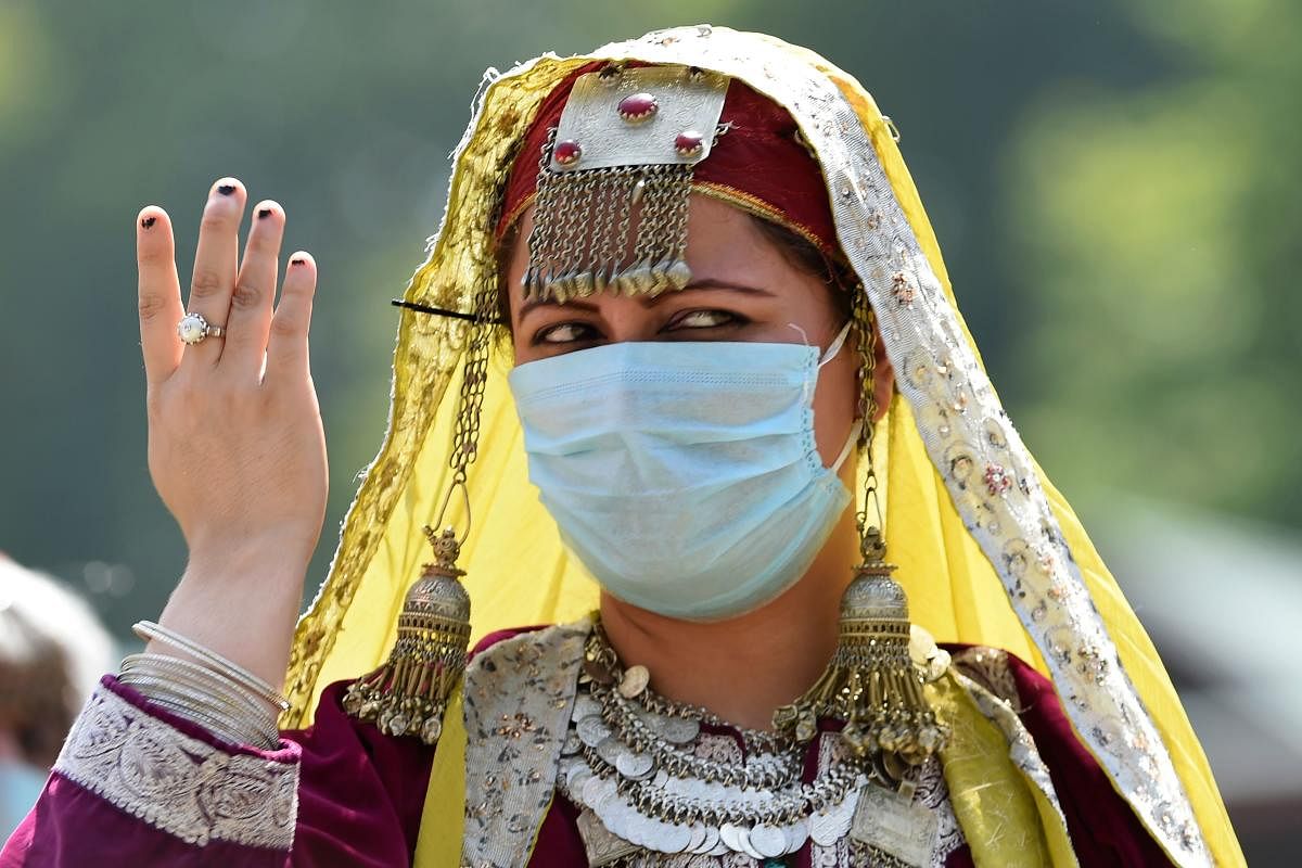 A woman dressed in traditional Kashmiri attire dances during a ceremony to celebrate India's 74th Independence Day.
