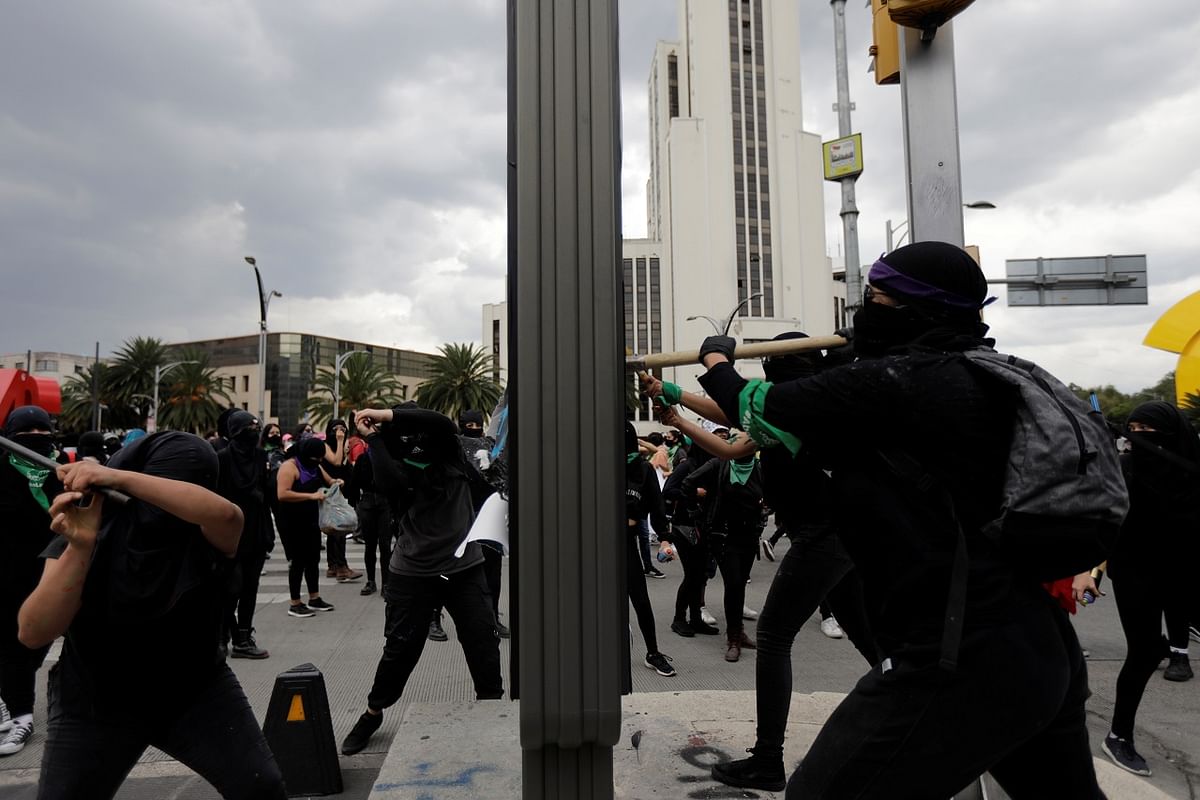 Protesters damage billboards during a march demanding justice for the victims of gender violence and femicides in Mexico City. Credits: Reuters Photo