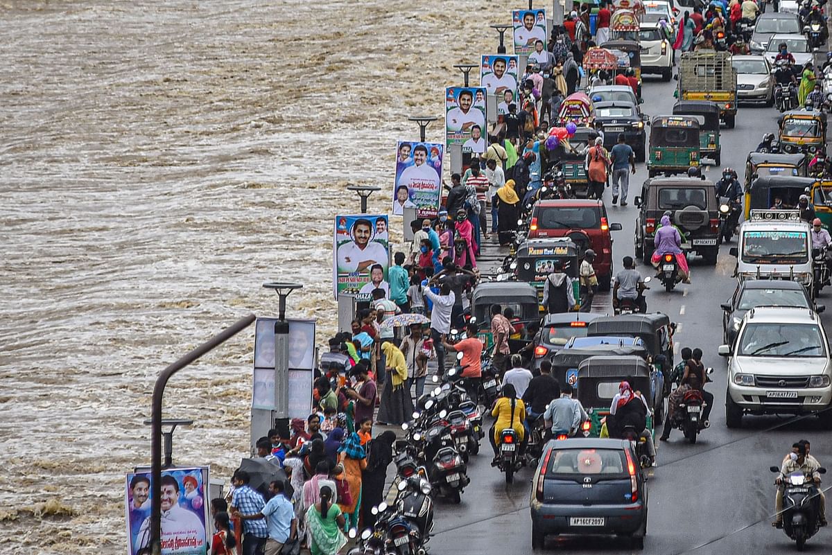People visit Prakasam Barrage as surplus water released into the Krishna river following heavy rains, in Vijayawada. Credits: PTI Photo