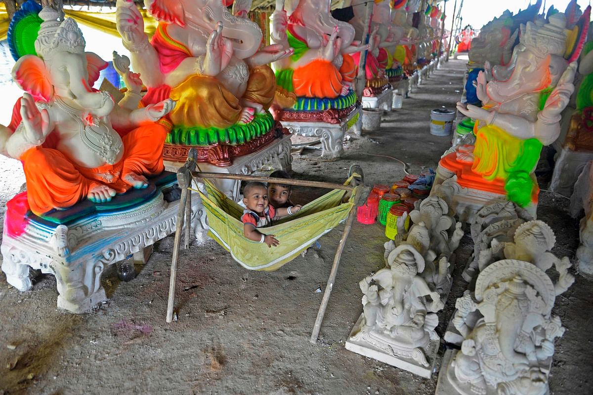 Children of artisans play amid idols of elephant headed Hindu god Ganesha, at a workshop ahead of the Ganesh Chaturthi festival, on the outskirts of Hyderabad. Credit: AFP