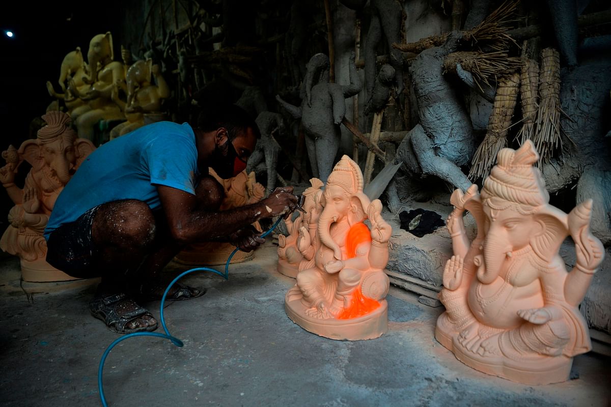 An artisans gives final touches to an idol of elephant headed Hindu god Ganesha at a workshop ahead of the Ganesh Chaturthi festival, in Siliguri. Credit: AFP