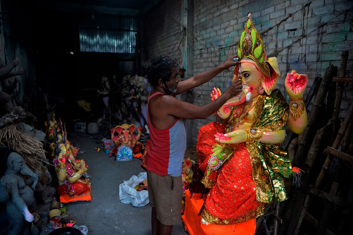 An artisan gives final touches to an idol of elephant headed Hindu god Ganesha at a workshop ahead of the Ganesh Chaturthi festival, in Siliguri. Credit: AFP