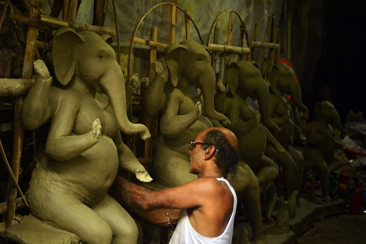 An artisan works on an idol of elephant headed Hindu god Ganesha at a workshop ahead of the Ganesh Chaturthi festival, in Siliguri. Credit: AFP