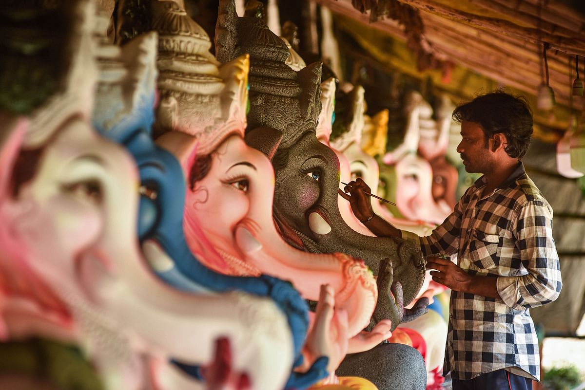 An artist gives a final touch to an idol of Lord Ganesha ahead of the Ganesh Chaturthi festival, at a workshop in Vijayawada. Credit: PTI
