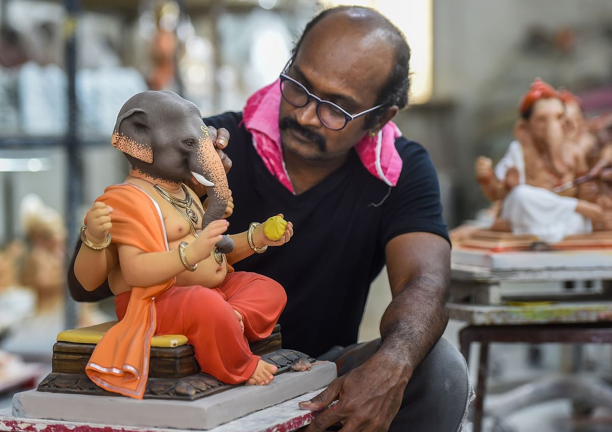 Artist Vishal Shinde (41) gives a final touch to a clay idol of Lord Ganesha ahead of the Ganesh Chaturthi festival, at his workshop in Worli, Mumbai. Credit: PTI