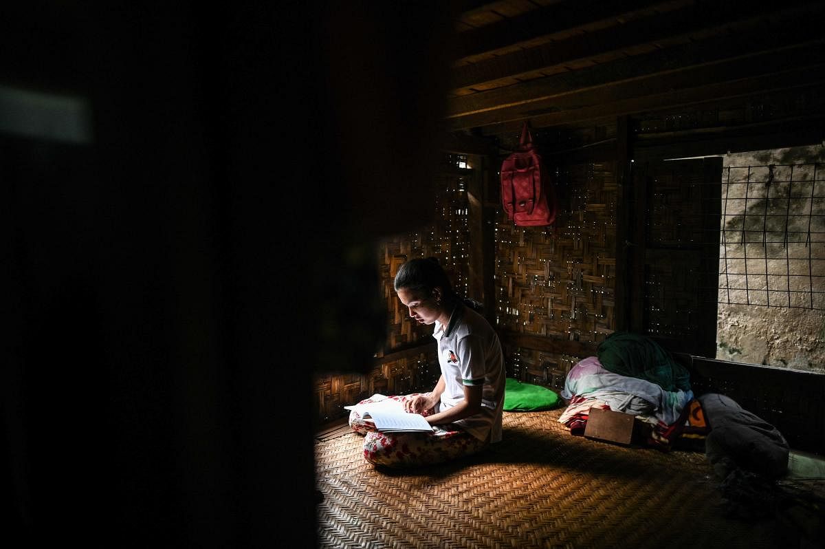 This photo taken on June 20, 2020 shows 18-year-old Muslim May Thandar Maung, who says she hasn't been able to get an ID card because of her religion and hence unable to vote in the upcoming election, studying Arabic and religion in her home in Meiktila, Mandalay Region. AFP