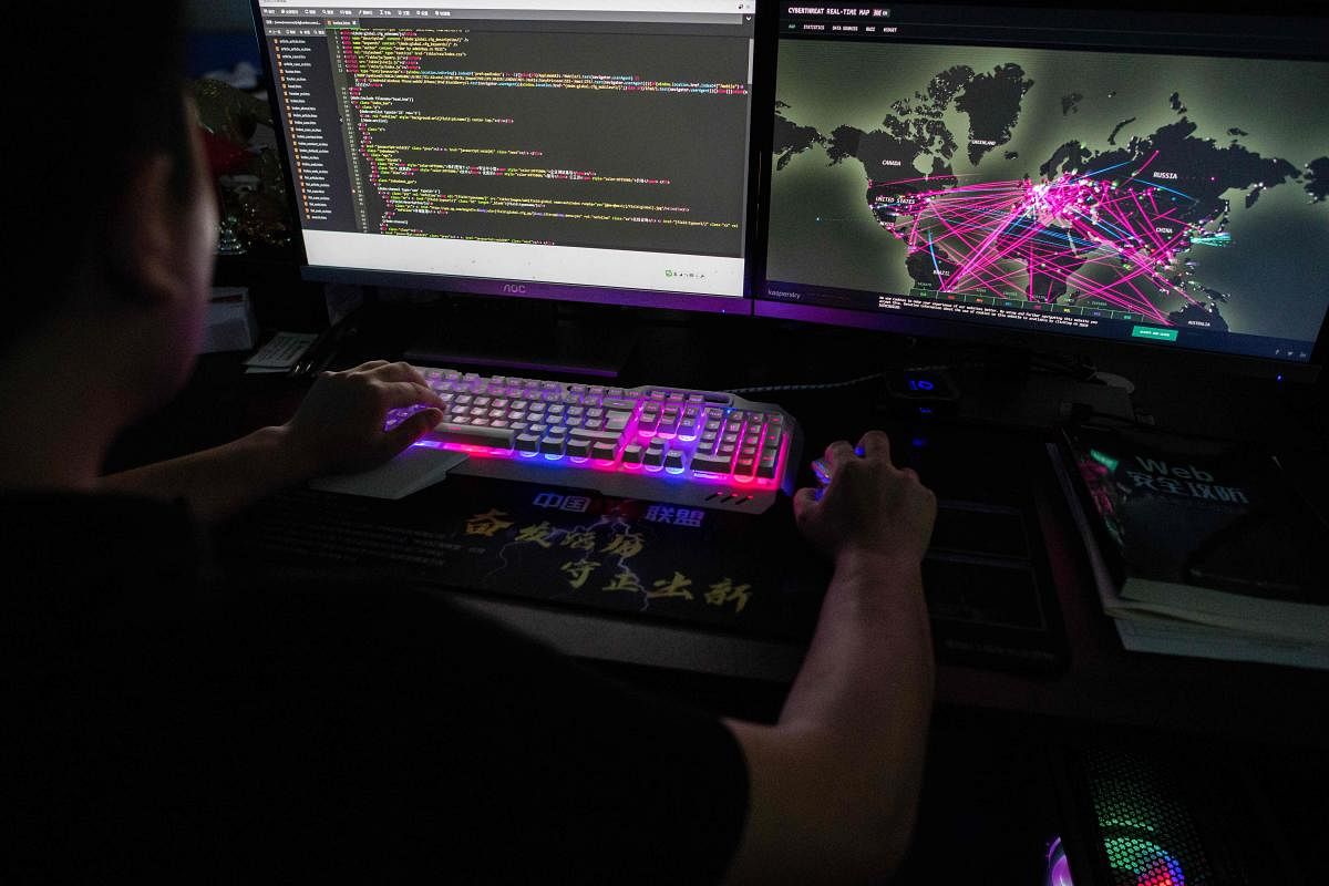 This photo taken on August 4, 2020 shows Prince, a member of the hacking group Red Hacker Alliance who refused to give his real name, using a website that monitors global cyberattacks on his computer at their office in Dongguan, China's southern Guangdong province. - From a small, dingy office tucked away in an industrial city in southern China, the Red Hacker Alliance -- one of China's most well-known patriotic