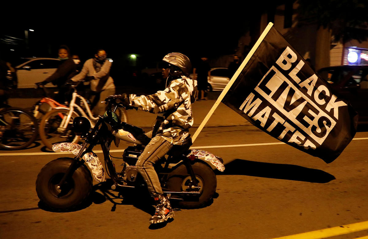 A demonstrator rides a motorbike with a Black Lives Matter flag during a protest over the death of a Black man, Daniel Prude, after police put a spit hood over his head during an arrest on March 23, in Rochester, New York, US. September 5, 2020. Credit: Reuters Photo