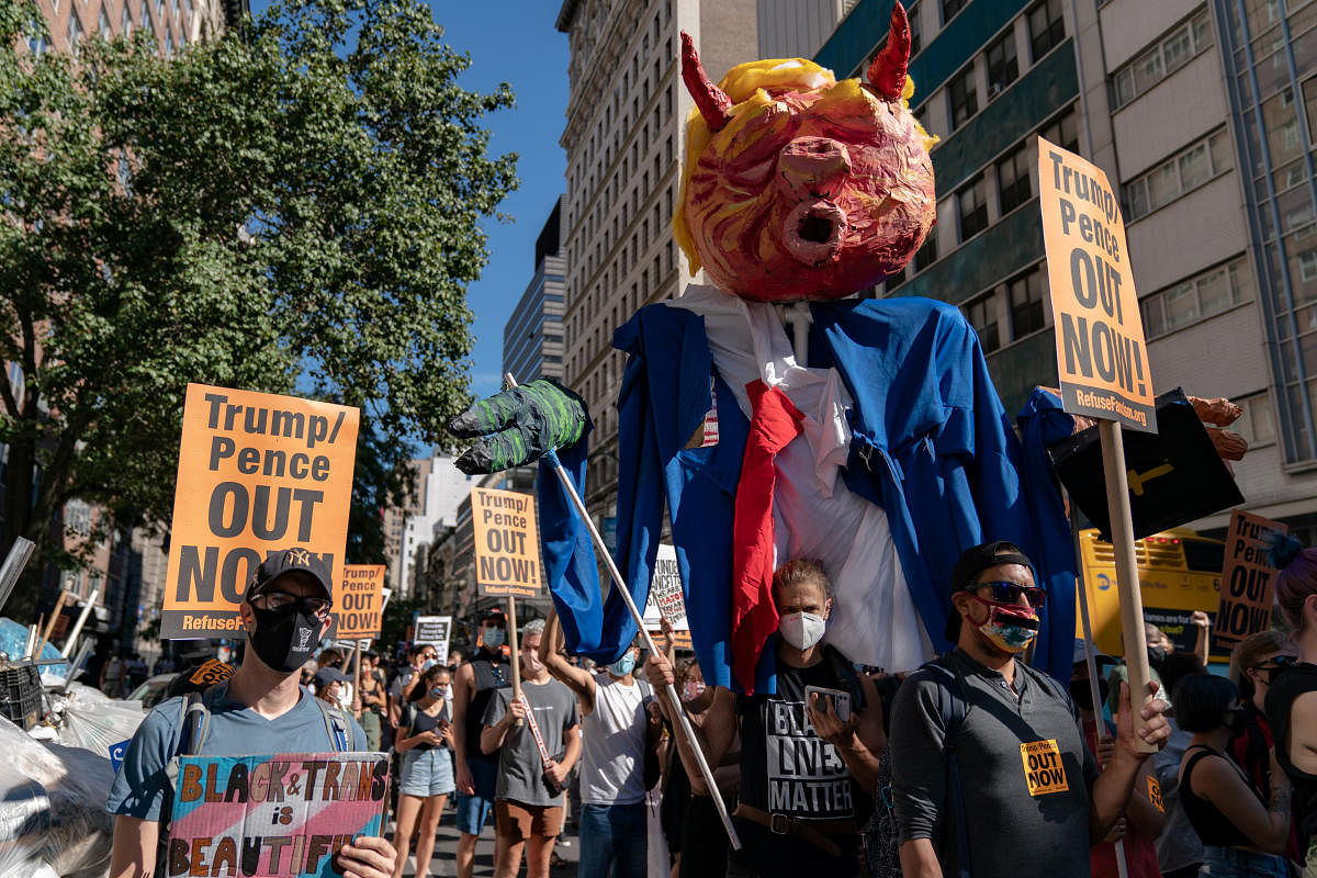 Protesters wearing protective masks hold signs during a march demanding Donald Trump and Mike Pence leave office on Union Square in the Manhattan borough of New York City, New York, US, September 5, 2020. Credit: Reuters Photo