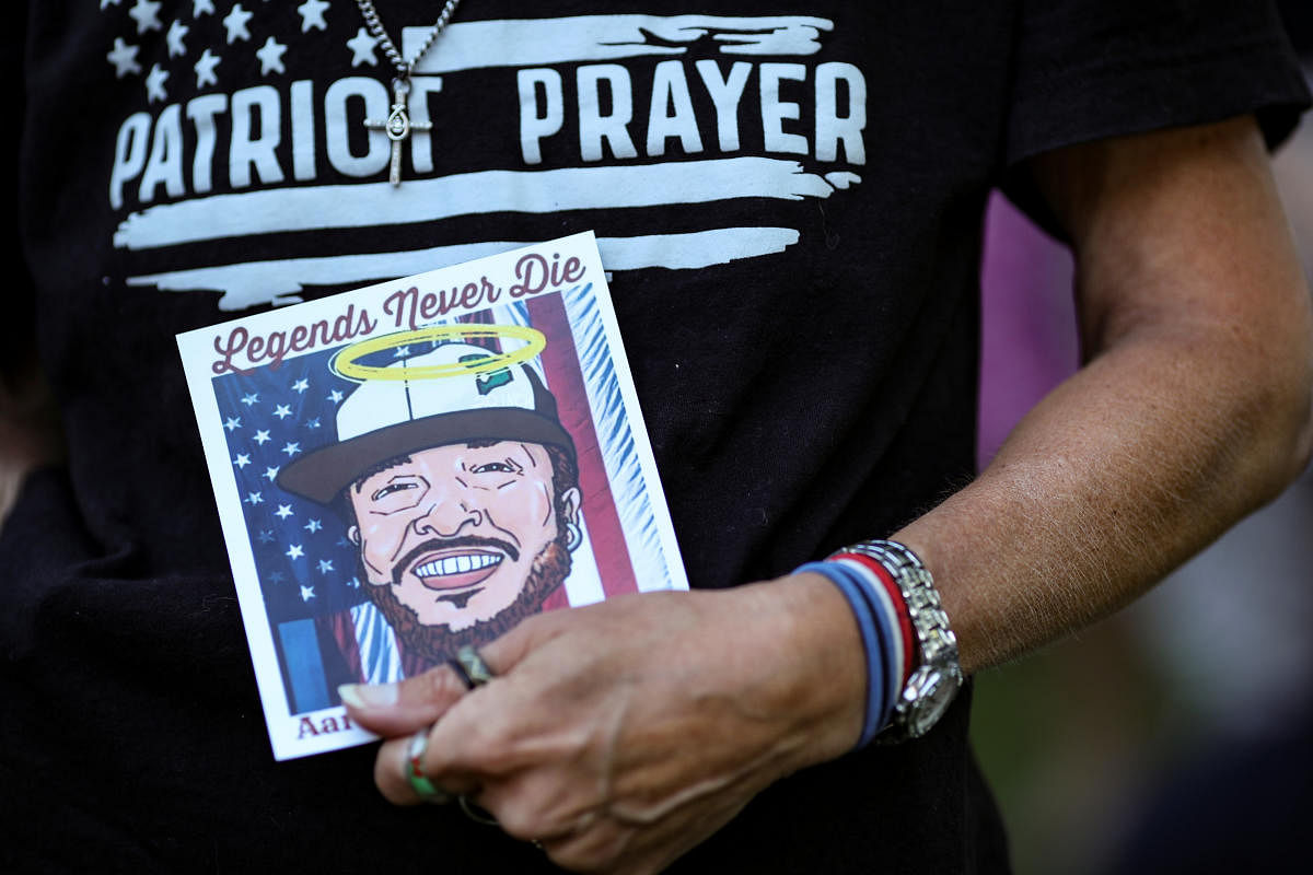 A drawing of Patriot Prayer supporter Aaron J Danielson is held by a participant of a gathering at a local park to remember Danielson, who was shot dead in Portland, Oregon after street clashes between supporters of President Donald Trump and counter-demonstrators, in Vancouver, Washington, US. September 5, 2020. Credit: Reuters Photo