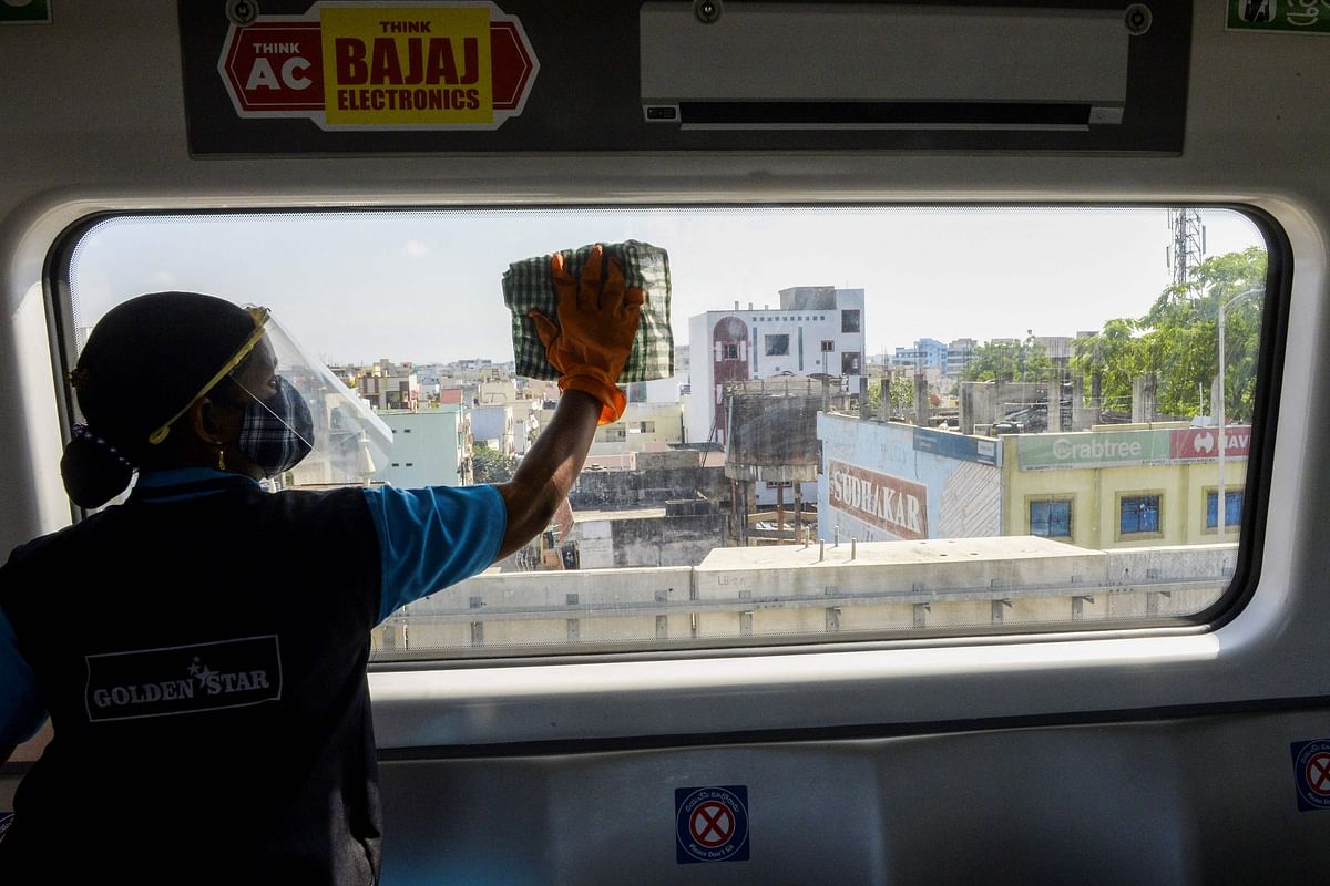 A worker cleans a carriage of a commuter train after passengers got out following the resumption of metro services after more than five months of shutdown due to the Covid-19 coronavirus pandemic, at a station in Hyderabad. Credit: AFP