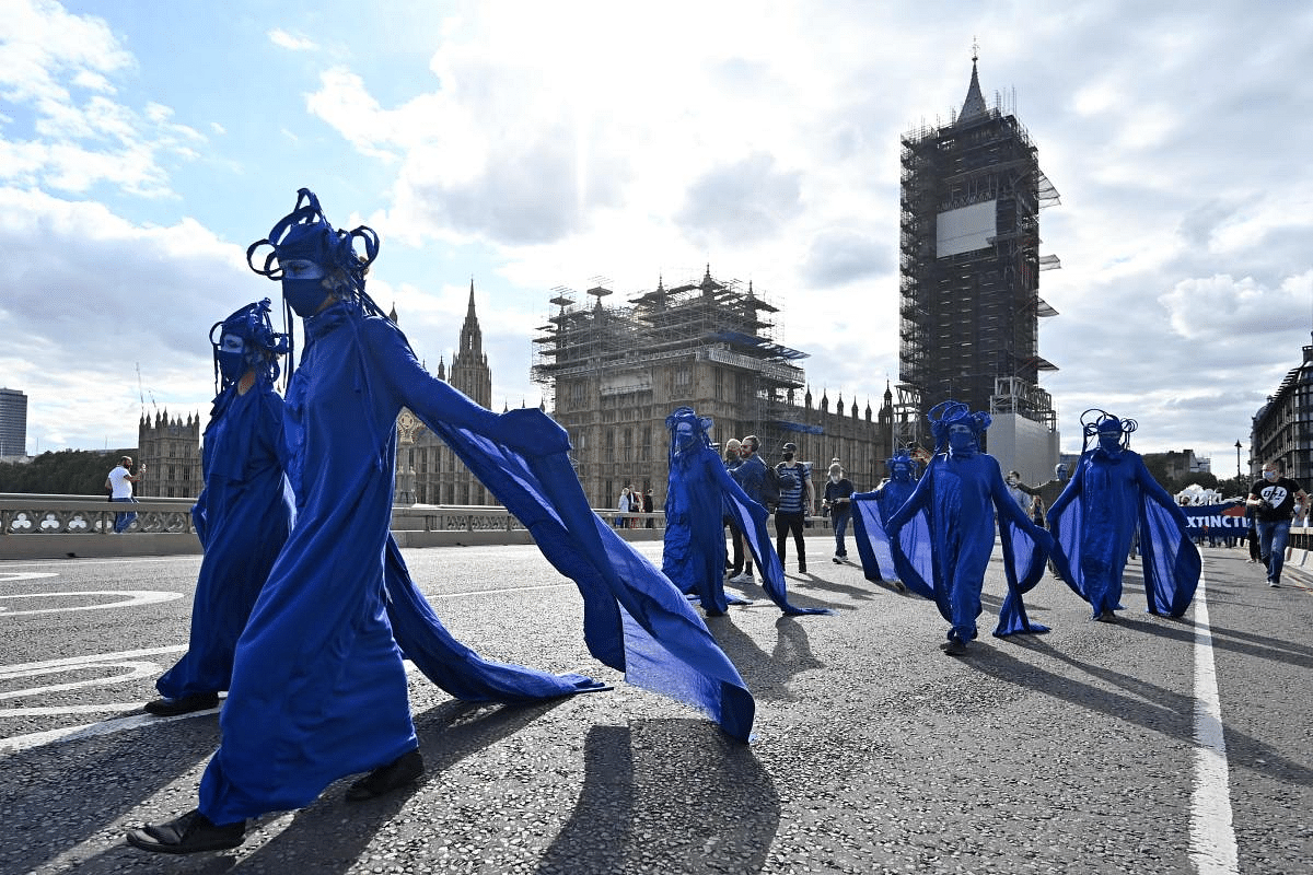 Activists from the climate change group Extinction Rebellion lead a procession across Westminster Bridge in central London on the sixth day of their new series of 'mass rebellions.' Credit: AFP Photo