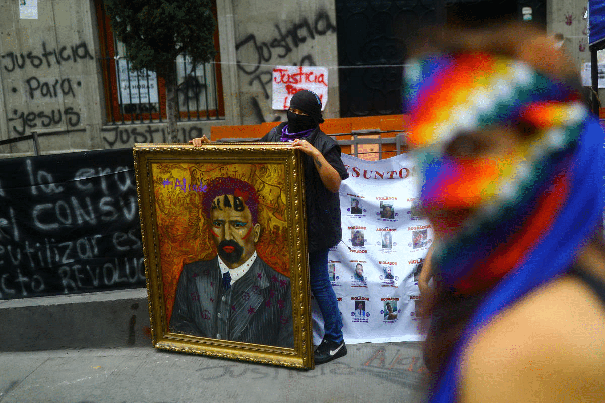 A feminist activist holds a picture of Francisco I. Madero, Mexican revolutionary, outside the National Human Rights Commission building after seizing the facilities of the organization for demand justice for the victims of gender violence and femicide in Mexico City, Mexico. Credit: Reuters Photo