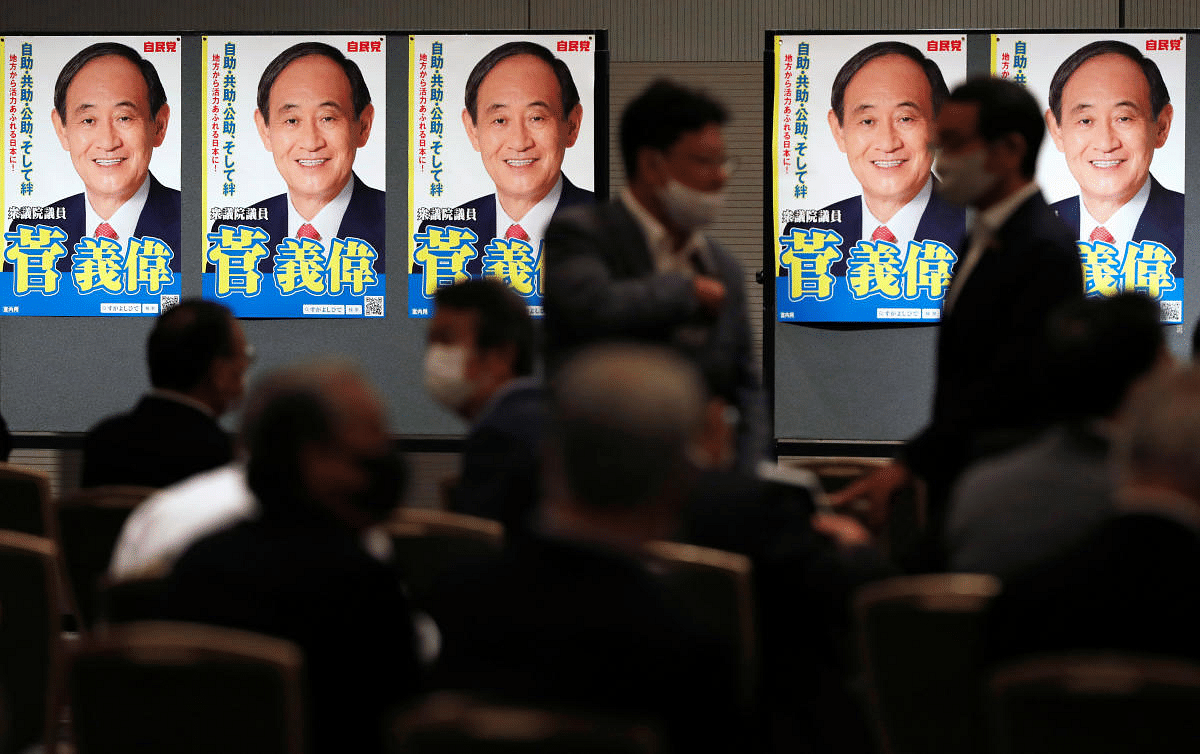 Supporters wearing face masks due to the ongoing coronavirus disease (COVID-19) outbreak are seen in front of posters of Japan's Chief Cabinet Secretary Yoshihide Suga before he officially kicks off his campaign rally for ruling Liberal Democratic Party's presidential election in Tokyo, Japan September 8 ,2020. Credit: Reuters Photo