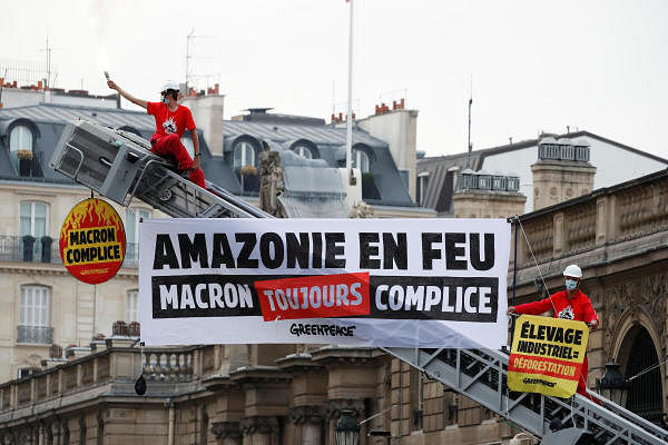 Greenpeace activists stand on a fire truck during an action in front of the Elysee Palace to protest against the ongoing damage to the Amazon rain forest, in Paris, France, September 10, 2020. The slogan reads