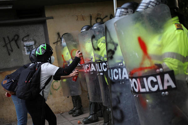 People spray paint on police riot shields as they protest outside a police station after a man, who was detained for violating social distancing rules, died from being repeatedly shocked with a stun gun by officers, according to authorities, in Bogota, Colombia. Credit: Reuters Photo